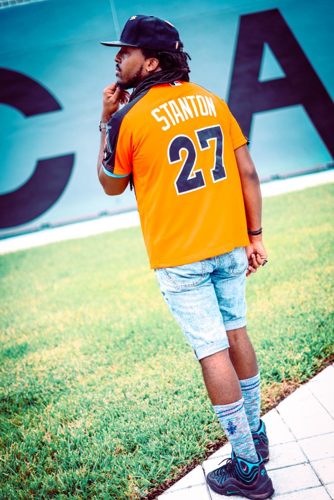 giancarlo stanton orange jersey, light wash denim shorts, blue multi colored calf socks, black turquoise and pink nike sneakers, black new york yankees strapback cap. How to style DIY denim shorts! 6 different outfits!