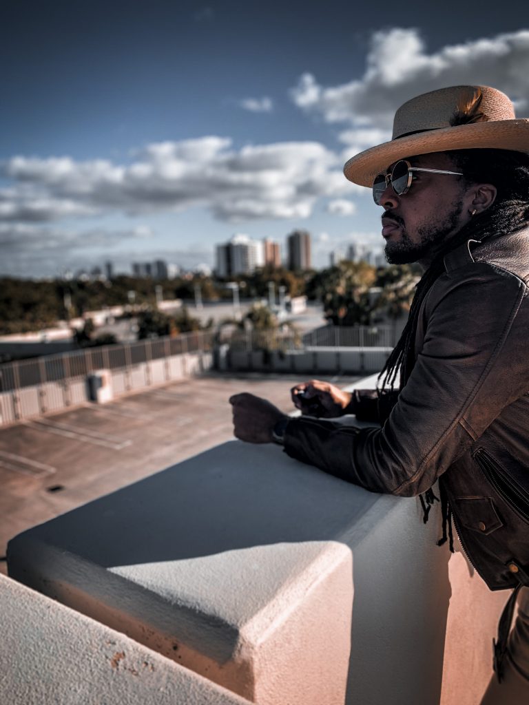 brown leather jacket, cream polo shirt with black chevron pattern, cream straw fedora, bone denim pants and black boots. 7 different ways to style Jodhpur boots!