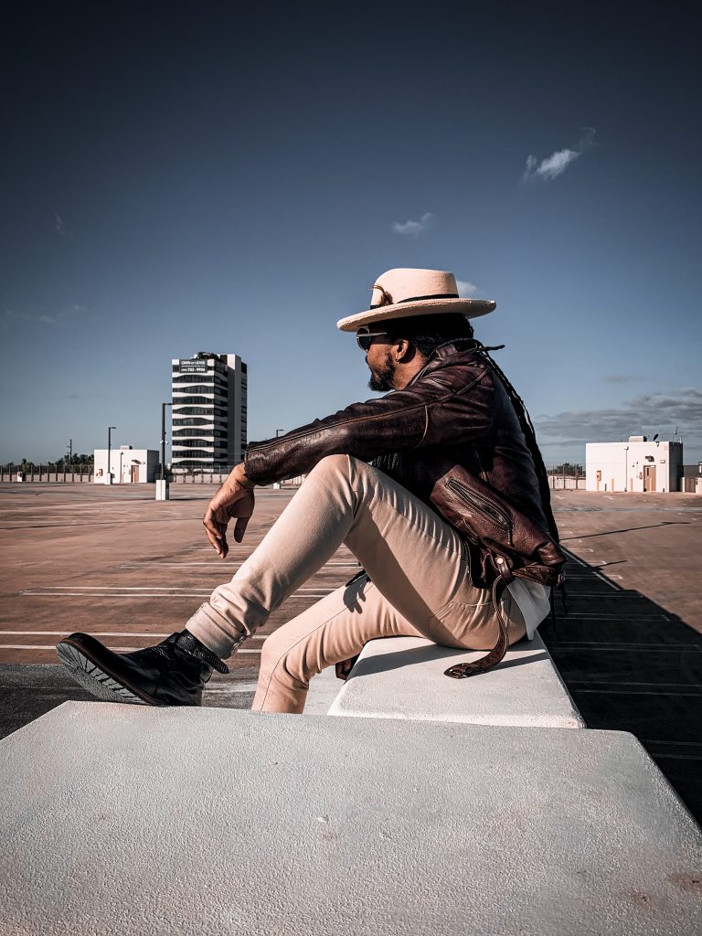 brown leather jacket, cream polo shirt with black chevron pattern, cream straw fedora, bone denim pants and black boots. 7 different ways to style Jodhpur boots!